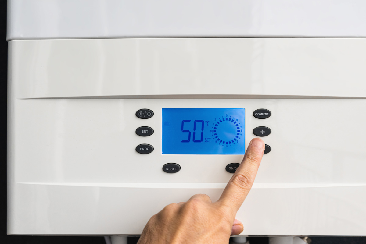 A person holds a heating radiator, demonstrating its size and design in a home setting.